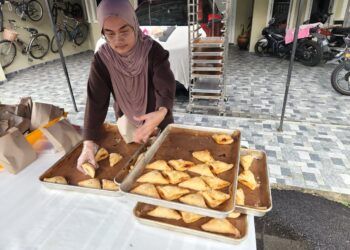 Sarah Anessofea Azhar menyusun pastri program Kongsi Rezeki Ramadan untuk diedarkan secara percuma kepada jiran-jiran di Saujana Utama, Sungai Buloh, Selangor semalam.