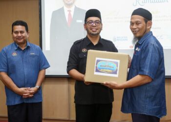 Dr. Zulkifli Hasan (tengah) menyampaikan sumbangan Ramadan Box kepada penerima di PSAS, Behrang di Tanjung Malim. - UTUSAN/MUHAMAD NAZREEN SYAH MUSTHAFA