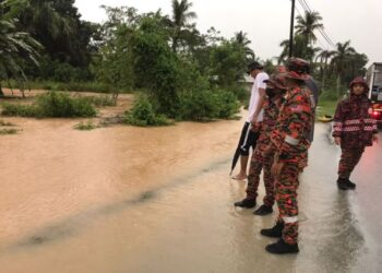 ANGGOTA bomba memantau situasi banjir kilat dan limpahan air sungai di Kampung Jimah Baru, Port Dickson berikutan hujan lebat yang berlaku sejak tengah hari tadi.-UTUSAN/ZAKKINA WATI AHMAD TARMIZI.