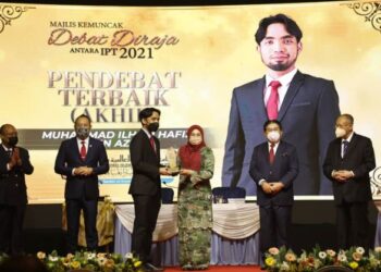 NORAINI Ahmad menyampaikan hadiah Pendebat Terbaik Peringkat Akhir Debat Diraja IPT 2021 kepada Muhammad Ilham Hafiz Azmi di Putrajaya hari ini. – UTUSAN/AMREE AHMAD