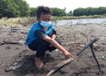 SEORANG kanak-kanak menunjukkan lokasi dia dan rakan-rakannya menemukan kepala manusia di tepi Pantai Kis, Tangerang, Indonesia. - AGENSI