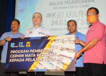 WEE Ka Siong  menyampaikan secara simbolik sumbangan cermin mata kepada wakil sekolah sempena Program CSR LPJ Cares Keluarga Malaysia Lembaga Pelabuhan Johor di Pasir Gudang, semalam.