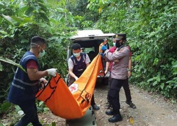 ANGGOTA keselamatan mengangkat mayat wanita yang ditemukan di pinggir Jalan Gampong Lambadeuk, Aceh.-SERAMBINEWS.COM