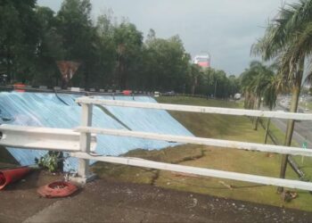 KAWASAN cerun di susur masuk Lebuhraya Persekutuan ditutup dengan kanvas selepas pergerakan tanah dikesan berlaku berhampiran Bulatan Kayangan di Seksyen 15 di Shah Alam, Selangor. - UTUSAN / ABDUL RAZAK IDRIS