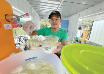 TUAN Muhammad Muiz Tuan Nordin menyiapkan cendol yang ditempah pelanggan di kios Versatile Cendol di Kampung Pachakan, Pasir Puteh, Kelantan. - UTUSAN/TOREK SULONG