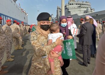 ANGGOTA Tentera Laut Saudi membantu rakyat Sudan yang dipindahkan di pangkalan tentera laut Raja Faisal di Jeddah.-AFP