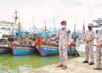 MOHD. Zubil Mat Som (kiri) meninjau empat bot nelayan Vietnam yang ditahan menerusi Op Kuda Laut Siri 3/2021 kerana menceroboh perairan negara. – UTUSAN/PUQTRA HAIRRY ROSLI