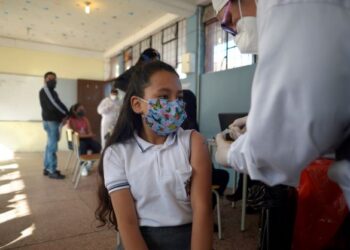 SEORANG kanak-kanak menerima suntikan vaksin Covid-19 di sebuah
pusat vaksinasi di Quito, Ecuador. – AFP