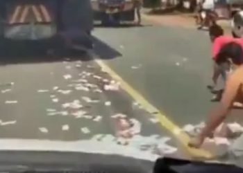 TANGKAP LAYAR video yang tular di laman media sosial memaparkan orang ramai berebut mengutip wang tunai bertaburan di sebuah jalan raya di Indonesia. - AGENSI