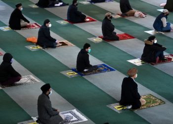 PENGANUT Islam memakai pelitup muka dan mengamalkan penjarakan sosial ketika mengerjakan solat Jumaat di Masjid Baitul Futuh di barat daya London, baru-baru ini. - AFP   