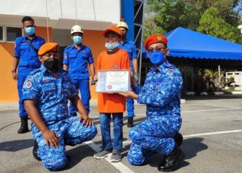 MUHAMMAD Haziq Mohd. Asyraf menerima sijil penghargaan Pertahanan Awam ‘Aura Prihatin Marga’ daripada Aminurrahim Mohamed (kanan) di Langkawi, Kedah. – UTUSAN/NUR AMALINA AZMAN