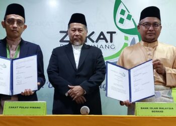 MOHAMAD Kairi Ghazali (kiri) dan Mohd. Nazri Chik (kanan) masing-masing menunjukkan dokumen yang ditandatangani pada majlis pemeteraian MoU berkaitan Pembiayaan Mikro i-TEKAD antara ZPP dengan BIMB di Bandar Perda, Bukit Mertajam.