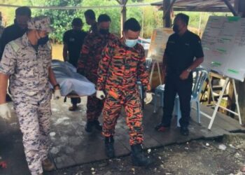 ANGGOTA bomba mengangkat mayat anggota PGA yang ditemukan lemas ketika memancing di perairan Lekir dekat Lumut hari ini. - UTUSAN/JBPM