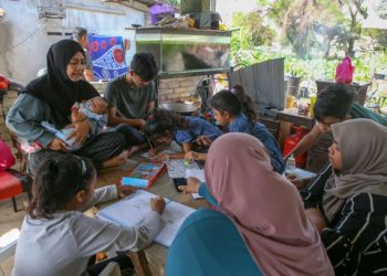 Saaidah Puteh (kiri) memantau anak-anaknya mengikuti PdPR di rumah mereka di Kampung Dewan Alor Malai, Alor Setar, Kedah. – Utusan/Shahir Noordin