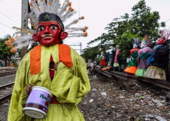 SEORANG peminta sedekah memakai kostum tradisional ondel-ondel di Jalan Kembang Pacar, Senen, Jakarta, Indonesia. - AGENSI