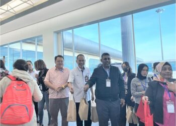 RAVEN Kumar (berjaket hitam) dan Kenedy Ayu (dua dari kiri) menyambut ketibaan pelancong China melalui penerbangan terus di Lapangan Terbang Antarabangsa Senai, Johor.