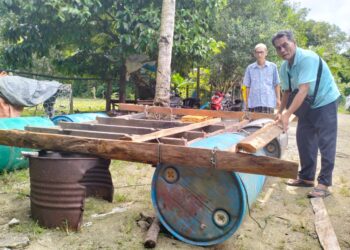 FAUZI Dollah menyiapkan bangsal terapung yang dibina menggunakan tong sebagai persediaan menghadapi banjir di Kampung Tok Rusa, Pasir Mas, Kelantan. - UTUSAN/ROHANA ISMAIL