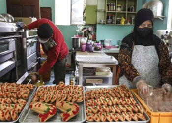 PUJIAH Bahran menyiapkan pesanan baulu ikan koi sempena sambutan Tahun Baharu Cina di kedainya di Jalan Yardi, Klang, Selangor. – UTUSAN / ZULFADHLI ZAKI