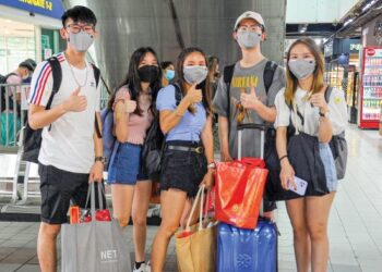 SOH Qian Qian (kanan) dan Hao Lin (dua dari kanan) bersama rakan-rakan sekerja mereka menunjukkan isyarat bagus sebaik sahaja tiba dari Singapura menggunakan laluan VTL untuk pulang sempena Tahun Baharu Cina di Terminal Larkin Sentral, Johor Bahru. – UTUSAN/RAJA JAAFAR ALI