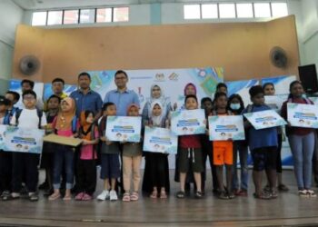 AKMAL Nasrullah Mohd. Nasir (tengah) bersama penerima kelengkapan sekolah dalam Majlis SWM Kasih Back To School di Dewan Flat Larkin, Johor Bahru, baru-baru ini.