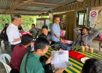 KHOO Poay Tiong (kiri) mengedarkan risalah kepada pengundi di sekitar Parlimen Kota Melaka, Melaka. - UTUSAN/MUHAMMAD SHAHIZAM TAZALI