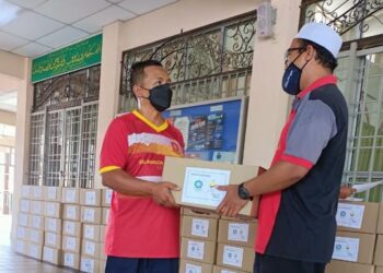 PEGAWAI MAIS (kanan) menyerahkan bantuan fidyah kepada penerima di sekitar Selangor.