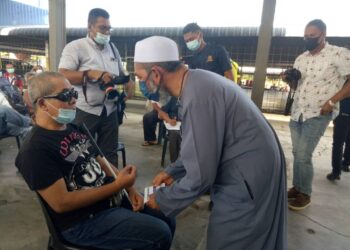 SYED Abu Hussin Hafiz Syed Abdul Fasal menyampaikan sumbangan kepada asnaf sempena Ramadan di Bukit Gantang hari ini. - UTUSAN/WAT KAMAL ABAS