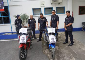 AZLI Mohd. Noor (tengah) bersama pegawai dari Bahagian Siasatan Jenayah melihat dua buah motosikal curi yang dirampas daripada dua suspek di Lipis, Pahang. - FOTO /IHSAN IPD LIPIS