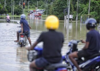 JALAN Gemas-Tampin dekat simpang Kem Syed Sirajudin, Gemas antara laluan yang ditutup untuk sebarang kenderaan buat sementara waktu selepas dinaiki air susulan banjir pagi tadi.-UTUSAN/MOHD. SHAHJEHAN MAAMIN