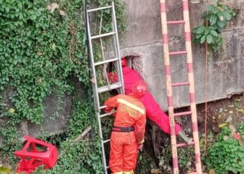 ANGGOTA bomba menyelamatkan seorang remaja yang terperangkap di dalam pembentung di Jakarta, Indonesia. - AGENSI