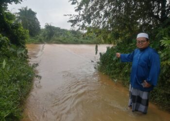 MOHD. Nasrun Abdullah meninjau keadaan jambatan yang ditenggelami air Sungai Telemong di Kampung Kepah, Hulu Terengganu, hari ini. - UTUSAN/NOOR HAYATI MAMAT