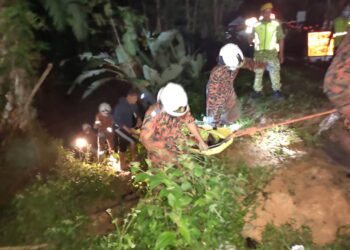 ANGGOTA bomba mengangkat mayat mangsa yang maut selepas terjatuh dari jambatan yang sedang dibaik pulih di Maran, Pahang.