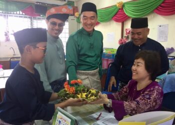 MUHAMMAD  Harith Mohamad Erman menghadiahkan buah gajus kepada gurunya,  Estee Quek Soh Theng sempena Hari Guru di SK Sultan Sulaiman I, Kuala Terengganu semalam. – UTUSAN/TENGKU DANISH BAHRI TENGKU YUSOFF