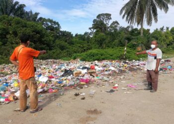 ABDUL Halim Yusuf (kanan) menunjukkan longgokan sampah yang dibuang penduduk di bahu jalan di Kampung Lubuk Lesung, Kijal di Kemaman pada 26 Jun 2021. - UTUSAN/
PUQTRA HAIRRY ROSLI