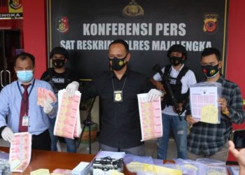 ANGGOTA polis menunjukkan kepingan duit palsu yang dirampas dalam satu operasi di Majalengka, Jawa Barat, Indonesia. - KOMPAS.COM