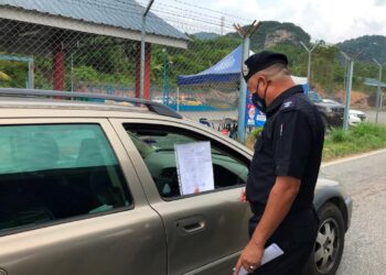 POLIS mengetatkan pemeriksaan ke atas kenderaan yang ingin melalui Jalan Gua Musang-Kuala Lipis di sekatan jalan raya (SJR) Tanah Putih, Gua Musang, Kelantan. - UTUSAN/AIMUNI TUAN LAH