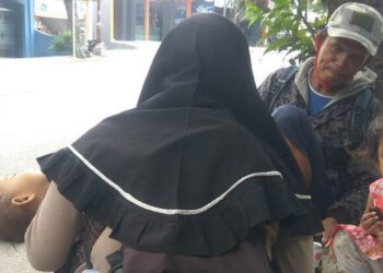 DANI berehat seketika bersama isteri dan dua anaknya sebelum meneruskan perjalanan ke Bandung dengan bejalan kaki. - AGENSI