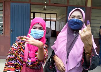 ZAUYAH Deraman (kiri) bersama ibunya, Fatimah Jusoh selesai membuang undi di SK Padang Mandol Tumpat, hari ini. -UTUSAN/ROHANA ISMAIL