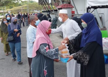 CHE Ibrahim Che Ismail (dua dari kanan) menyampaikan wang zakat kepada penerima di Hentian Gua Musang, semalam. - UTUSAN/AIMUNI TUAN LAH