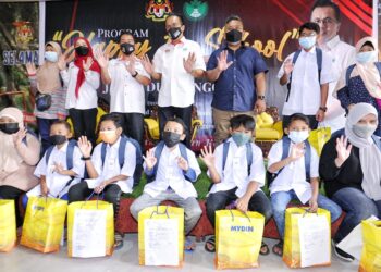 MOHD. Salim Mohd. Sharif (belakang, tengah) dalam program sumbangan  barangan kembali ke sekolah Happy To School di Kampung Rawa, Lenggeng, Seremban hari ini.  Dalam majlis tersebut Risda memohon tiga negara pengeluar utama perlu sepakat kawal harga getah. -UTUSAN/MOHD. SHAHJEHAN MAAMIN