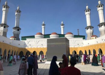 ORANG ramai bergambar kenangan bersama replika Kaabah selepas solat sunat Hari Raya Aidilfitri di Masjid Razaleigh, Gua Musang hari ini. - UTUSAN/AIMUNI TUAN LAH