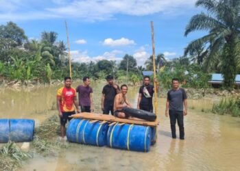 SEKUMPULAN anak muda membina rakit untuk memindahkan mangsa banjir yang terperangkap di Kampung Sri Tanjung, Dengkil, Selangor. - FOTO/SITI A’ISYAH SUKAIMI