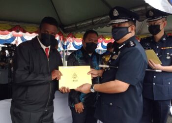 A. ASMADI Abd. Aziz (kanan) menyampaikan surat penghargaan kepada salah seorang penerima  pada Perbarisan Peringatan Hari Polis ke-214 di Kompleks Latihan Sukan Kontinjen Perak di Ipoh hari ini. - UTUSAN/ZAKI SALLEH