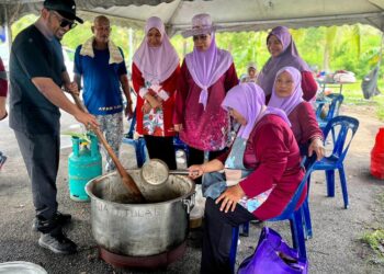 WAN Zikri Afthar Ishak (kiri) mengacau bubur kacang sewaktu Program Sukan Rakyat Sempena Hari Keputeraan Raja Perlis Ke-80 di Masjid Ibnu Tamiyyah, Tambun Tulang, Arau, Perlis hari ini. -UTUSAN/ASYRAF MUHAMMAD