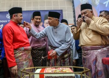 AHMAD Zahid Hamidi menyuap kek kepada Fathul Bari Mat Jahya selepas bersama
memotong kek sempena ulang tahun UMNO yang ke-77 pada Majlis Rumah Terbuka Aidilfitri UMNO Perlis di Dewan Sivik Arau, Perlis hari ini. - UTUSAN/ SHAHIR NOORDIN