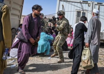 TENTERA AS menghalakan senjata ke arah penumpang Afghanistan di Lapangan Terbang Kabul. -AFP