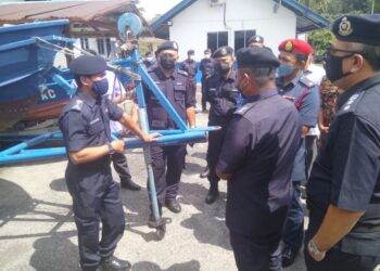 ROHAIMI Md. Isa (kiri) memberikan taklimat kepada petugas keselamatan mengenai banjir gelombang ketiga di Balai Polis Kuala Jengai di Dungun, hari ini.