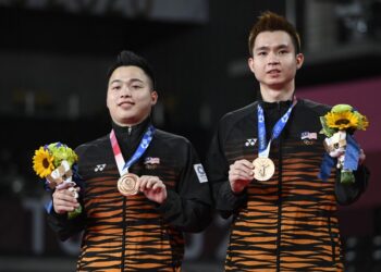 AARON Chia (kiri) dan Soh Wooi Yik bersama pingat gangsa Sukan Olimpik yang dimenangi selepas menewaskan Mohamad Ahsan-Hendra Setiawan. - AFP