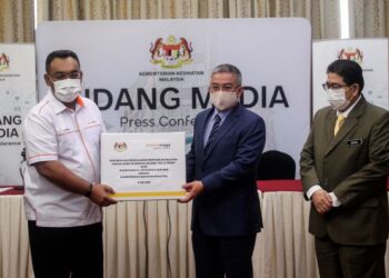 DR. ADHAM Baba (tengah) menerima penyerahan pengeluaran pertama di Malaysia vaksin Covid-19 Sinovac daripada Pengarah Urusan Kumpulan Pharmaniaga Bhd., Datuk Zulkarnain Md Eusope (kiri) pada majlis Penyerahan Vaksin Sinovac daripada Pharmaniaga di Kementerian Kesihatan, Putrajaya hari ini. - FOTO/FAISOL MUSTAFA