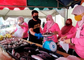 ADI Putra menimbang ikan untuk dijual dalam Program Pasar Pagi Puteri di Kampung Parit,Kota Bharu, Kelantan. - UTUSAN/ROHANA MOHD. NAWI